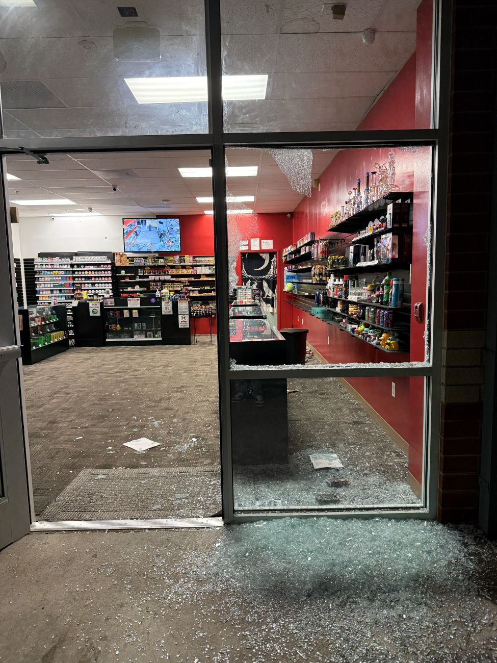 Storefront glass shattered in a break-in, awaiting emergency replacement